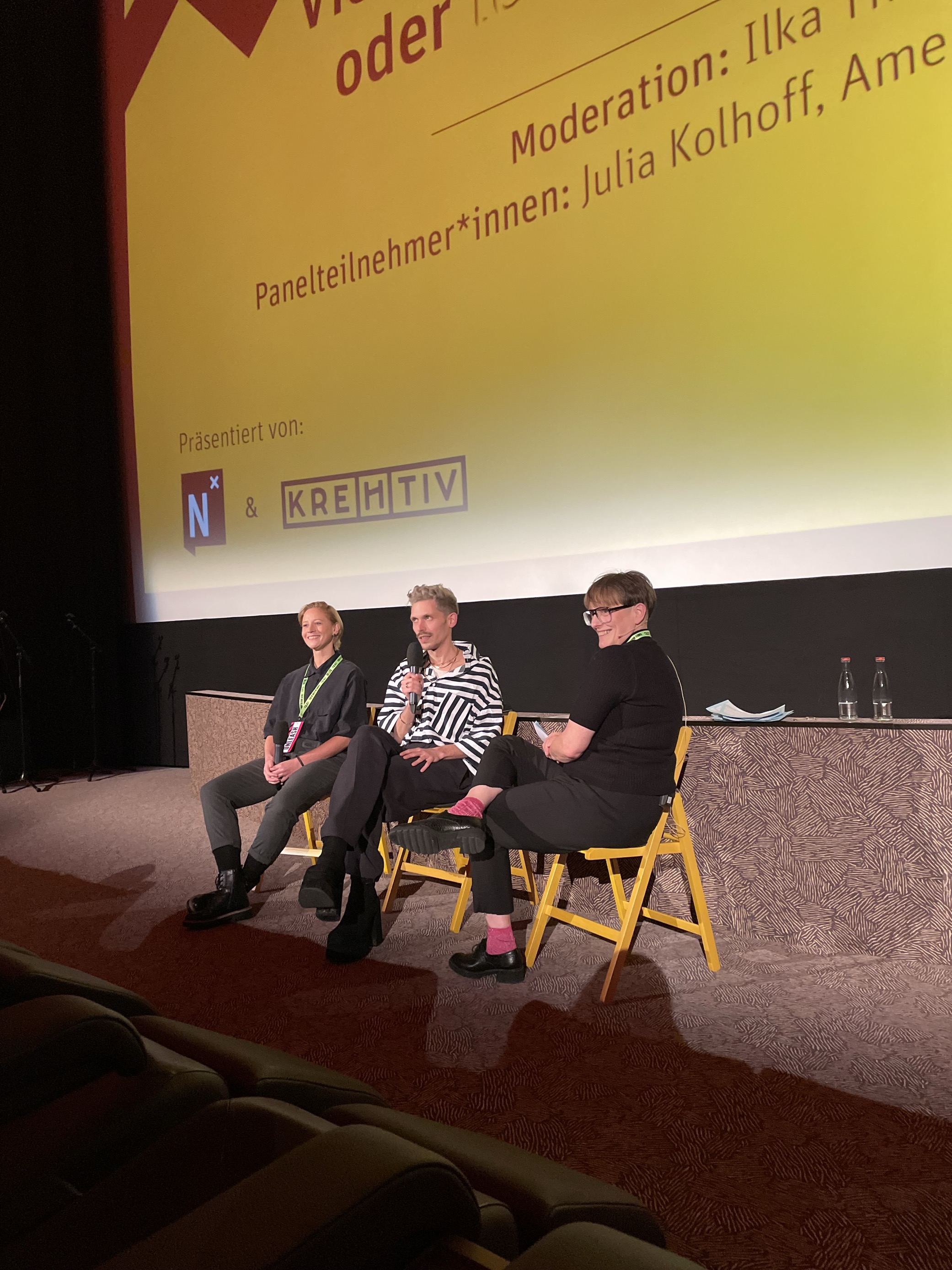 Julia, Lukas und Ilka sitzen gemeinsam auf der Bühne und unterhalten sich.