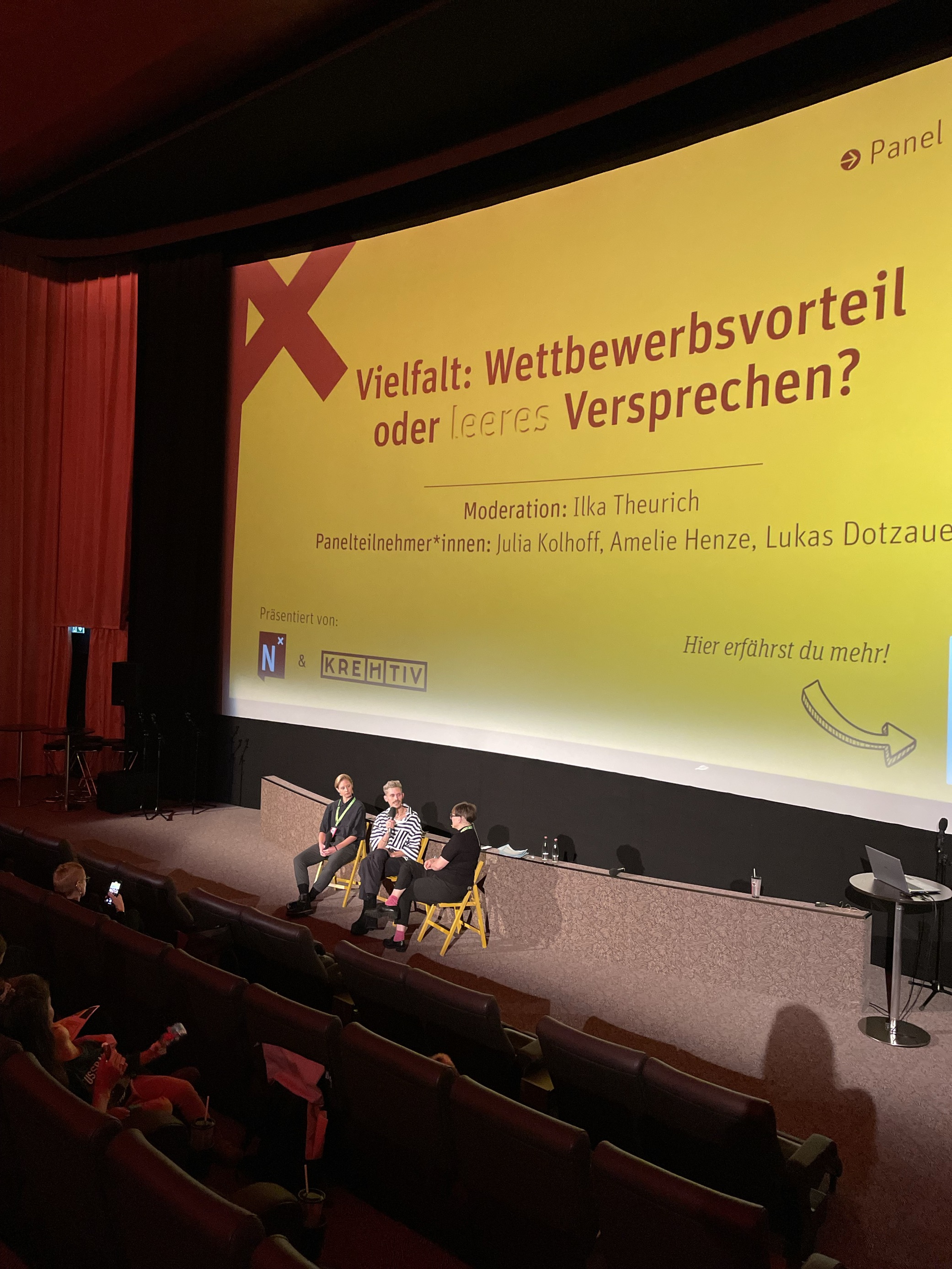Julia, Lukas und Ilka sitzen gemeinsam auf der Bühne und unterhalten sich.
